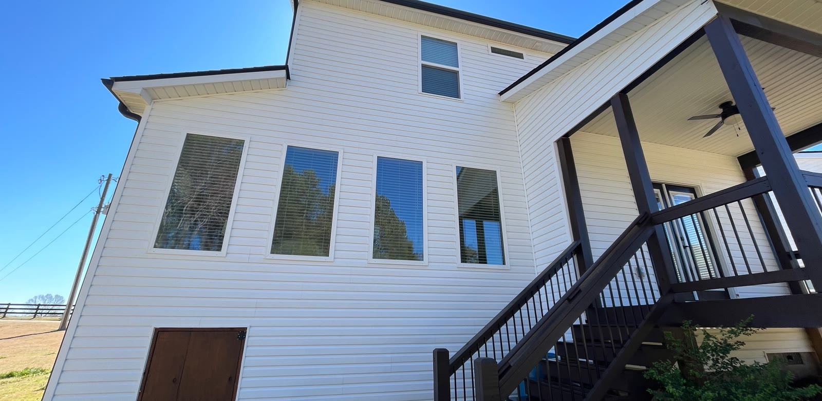 Clean white siding after a completed CK Pressure Washing house wash